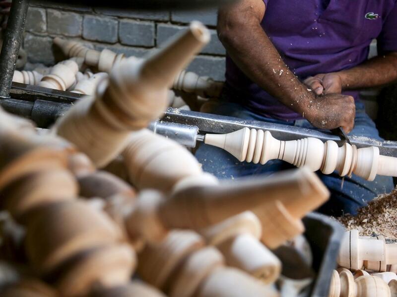 A carpenter shaves a piece of wood to make a narguileh (water pipe) at his workshop in Iraq's central holy city of Karbala on October 21, 2020. MOHAMMED SAWAF / AFP