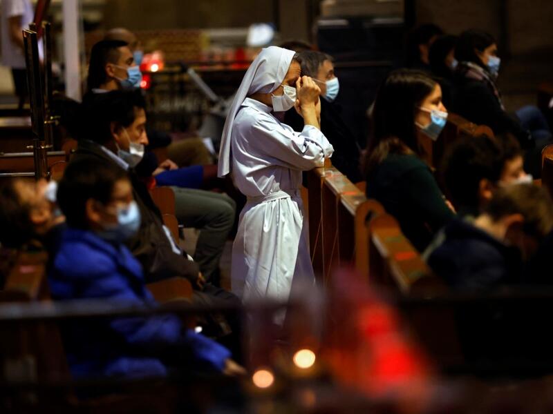 A nun prays during the All Saints' Day mass at the Sacre-Coeur basilica (Sacred Heart Church), in Paris, on November 1, 2020 as France's security forces are on high alert for the All Saints Catholic holiday after a string of attacks blamed on suspected Islamists in recent weeks. THOMAS COEX / AFP