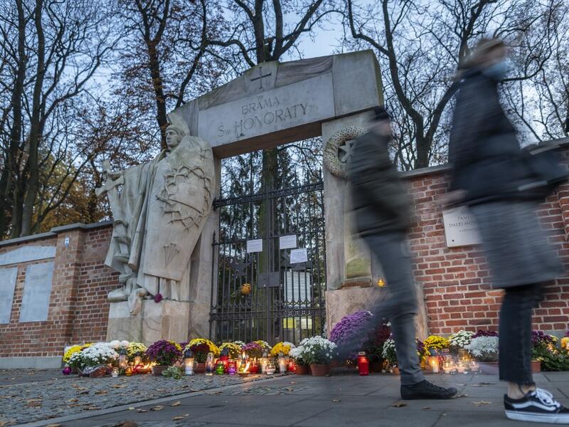 Candles and flowers lay in front of the locked gate to Powazki cementary in Warsaw, Poland, on November 1, 2020, while the polish government closed cemeteries due to COVID-19 restrictions two days before the All Saints' Day, preventing Poles from visiting their loved ones graves according to tradition. The Polish government announced on October 30, 2020 the closure of cemeteries for three days, around All Saints' Day, to curb the outbreak of new contaminations in the country. Wojtek RADWANSKI / AFP