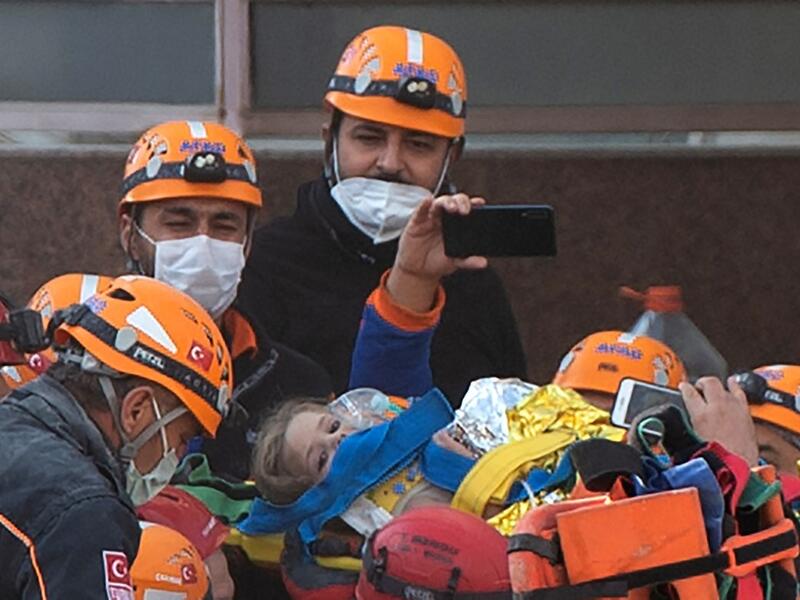 Rescue workers carry three-year-old girl Ayda Gezgin as they pull her out of the rubble of a building 91 hours after it collapsed during a 7.0-magnitude earthquake, at Bayrakli district in Izmir, on November 3, 2020. (AFP)