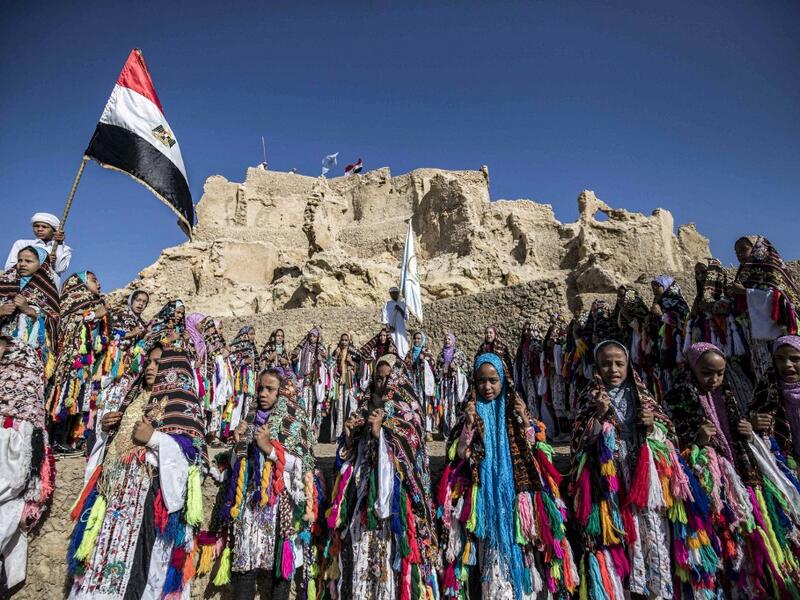 Egyptian school children dressed in traditional outfits, gather during a celebration to mark the inauguration of the fortress of Shali following its restoration, in the Egyptian desert oasis of Siwa, some 600 kms southwest of the capital Cairo, on November 6, 2020. Khaled DESOUKI / AFP