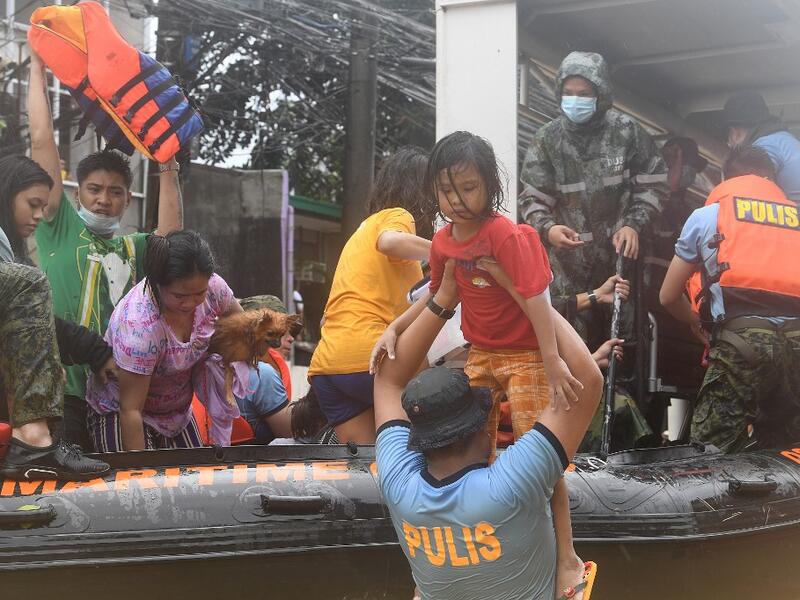 Rescuers evacuate residents from their flooded homes after Typhoon Vamco hit, in Marikina City, suburban Manila on November 12, 2020. Ted ALJIBE / AFP