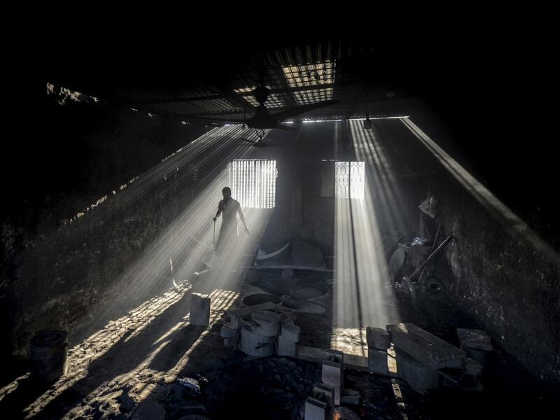 In this picture taken on November 12, 2020 a dockyard worker makes a propeller of a ship on the banks of the Buriganga River in Char Kaliganj on the outskirts of Dhaka. Rivers are the lifeblood of the delta nation of 168 million people where much of the low-lying land is accessed via boat, with Bangladesh's strong economic growth of recent years fuelling more investments in new and bigger ships. Munir UZ ZAMAN / AFP