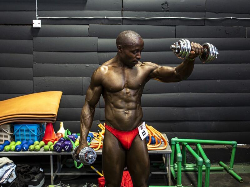 A bodybuilder warms up backstage before competing in the Iron Fit Bodybuilding competition in Nairobi on December 05, 2020. 130 participants from all across East Africa took part in the second edition of this competition which included categories like Bikini, Figure, Physique and Bodybuilding. Patrick Meinhardt / AFP