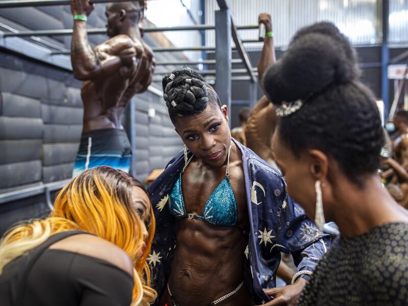 Bodybuilders gather in the backstage warming up area before taking aprt in the Iron Fit Bodybuilding competition in Nairobi on December 05, 2020. 130 participants from all across East Africa took part in the second edition of this competition which included categories like Bikini, Figure, Physique and Bodybuilding. Patrick Meinhardt / AFP