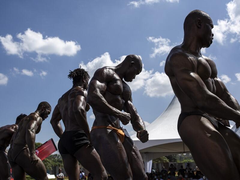 Bodybuilders pose on stage during the Iron Fit Bodybuilding competition in Nairobi on December 05, 2020. 130 participants from all across East Africa took part in the second edition of this competition which included categories like Bikini, Figure, Physique and Bodybuilding. Patrick Meinhardt / AFP