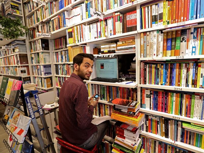 An Iranian employee works on a computer at a bookstore in Tehran's Enqelab (Revolution) street, on September 8, 2020. ATTA KENARE / AFP
