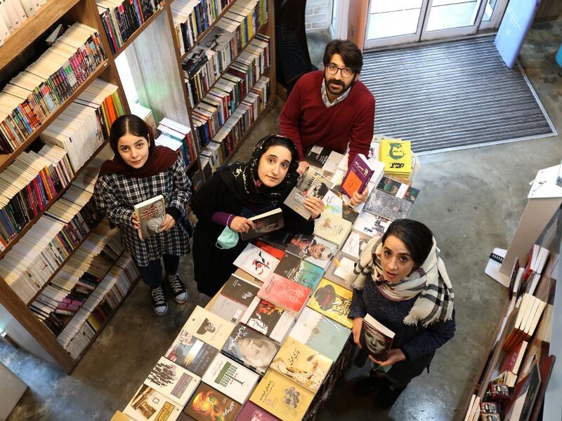 Employees pose for a picture at a bookstore of the Nashre-Cheshmeh Publishing House on Karim Khan street in the Iranian capital Tehran, on December 5, 2020. ATTA KENARE / AFP