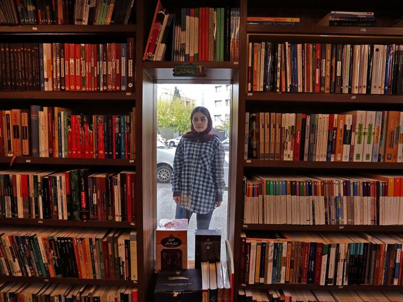 Employee Sepideh Daryan poses for a picture at a bookstore of the Nashre-Cheshmeh Publishing House in the Iranian capital Tehran, on December 5, 2020. ATTA KENARE / AFP