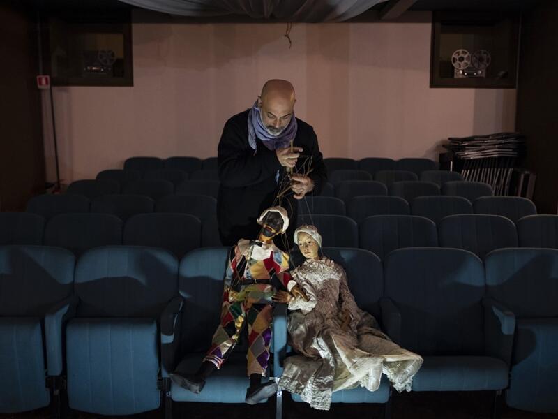 Marco Grilli holds two puppets in the parterre at the " Alfa Theatre" in Turin, on November 30, 2020. The Grilli family has a collection of more than 20,000 objects from around the world, everything from theatres, marionettes and glove puppets to shadow figures and silhouettes. A long-time dream of Grilli and his wife Mariarosa, 78, the museum is due to open in 2023 in Turin, financed both privately and publicly with the help of different institutions.  Marco Bertorello / AFP