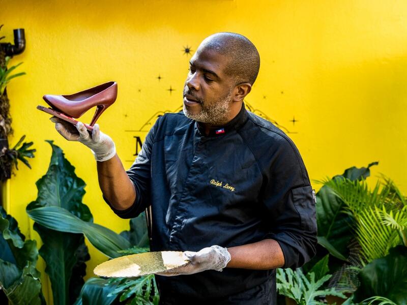 Ralph Leroy, chocolate maker, entrepreneur and chocolate sculptor, poses with one of his emblematic creations, a shoe in the workshops of Makaya Chocolat on December 23, 2020 in Petionville, Haiti. Although small in the face of South America's giants, Haiti is slowly developing its cocoa industry to ensure better incomes for thousands of modest farmers and to end the stereotype of gastronomic art known as the domain of wealthy countries. Valerie Baeriswyl / AFP