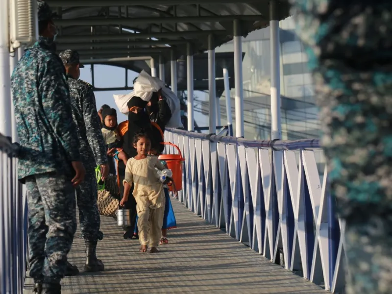 Rohingya refugees embark on a Bangladesh Navy ship as they are relocated to the controversial flood-prone island Bhashan Char in the Bay of Bengal, in Chittagong on December 29, 2020. Rehman ASAD / AFP