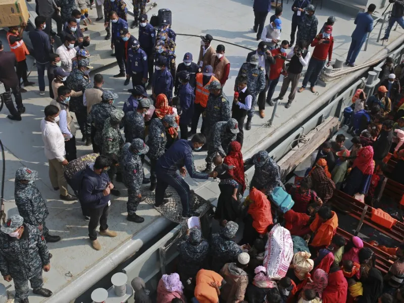 Rohingya refugees disembark from a Bangladesh Navy ship as they are relocated to the controversial flood-prone island Bhashan Char in the Bay of Bengal, in Chittagong on December 29, 2020. REHMAN ASAD / AFP