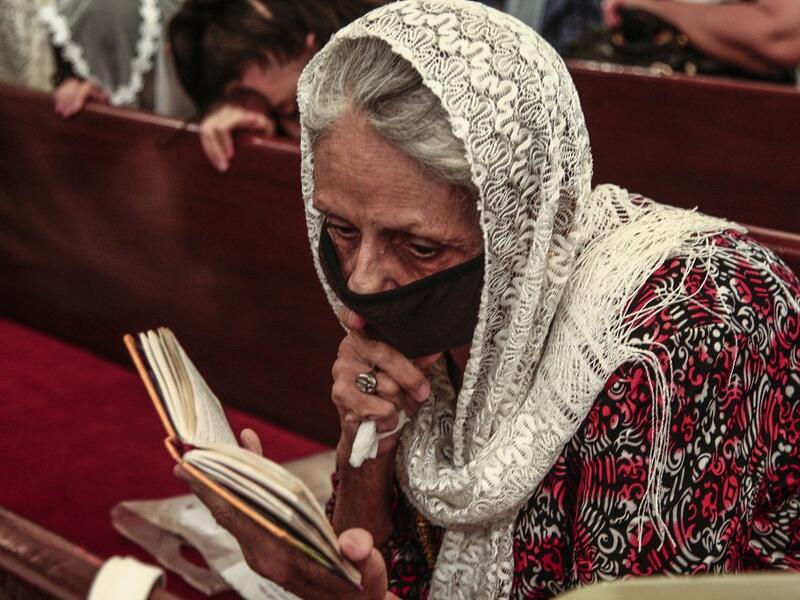 A Sudanese Copticwoman attends Christmas midnight mass at the capital Khartoum's Martyrs Church late on January 6, 2021, as the Orthodox Christian faith uses the old Julian calendar in which Christmas falls 13 days after the date in the more widespread Gregorian calendar.  Ebrahim HAMID / AFP