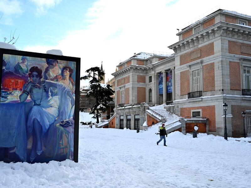 A man walks past the Prado Museum in Madrid on January 10, 2021. Snowstorms in Spain left three people dead and caused chaos across much of the country, trapping motorists and shutting down the capital's air and rail links. Gabriel BOUYS / AFP