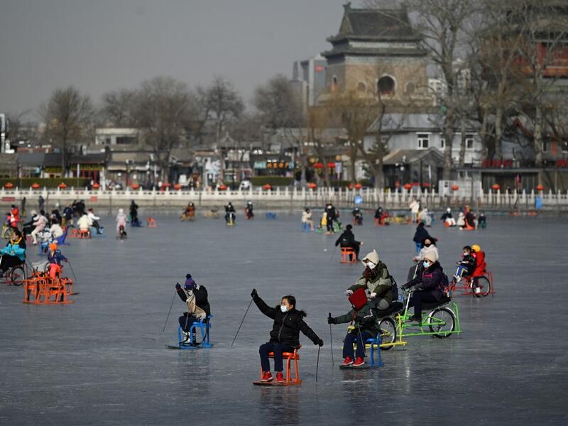 People use sleds on a frozen lake in Beijing on January 12, 2021. WANG Zhao / AFP