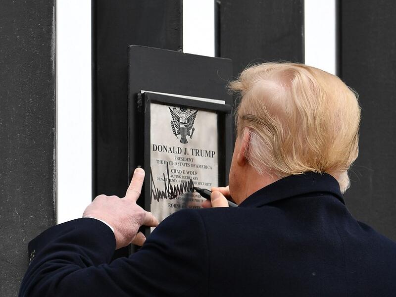 US President Donald Trump signs plaque on the border wall in Alamo, Texas on January 12, 2021. MANDEL NGAN / AFP