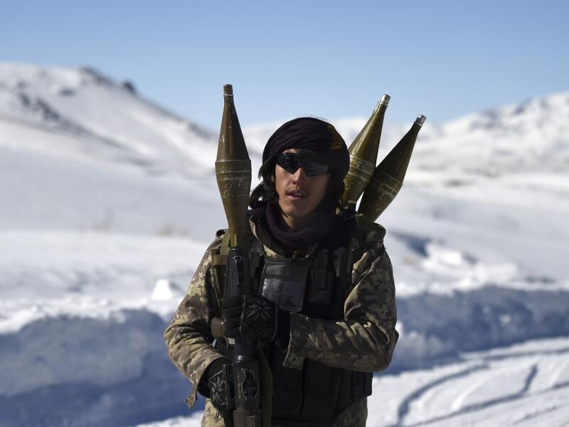 In this photo taken on January 9, 2021, a Hazara armed militia for the Resistance for Justice Movement, holds a rocket-propelled grenade (RPG) as he walks along a road during a patrol against Taliban insurgents at Hisa-e-Awali Behsud district of Maidan Wardak Province. Comprising roughly 10 to 20 percent of Afghanistan's 38-million population, Hazaras have long been persecuted for their largely Shiite faith by Sunni hardliners in a country wracked by deep ethnic divisions. WAKIL KOHSAR / AFP