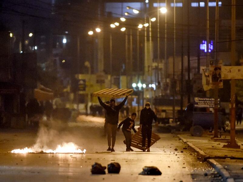 Protesters block a street during clashes with security forces in the Ettadhamen city suburb on the northwestwern outskirts of Tunisia's capital Tunis on January 17, 2021, amidst a wave of nightly protests in the North African country. FETHI BELAID / AFP