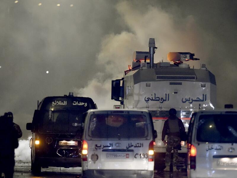 Tunisian security forces gather as protesters block a street in the Ettadhamen city suburb on the northwestern outskirts of Tunis on January 18, 2021, amidst a wave of nightly protests in the North African country. The social unrest comes at a time of economic crisis, worsened by the pandemic, that has sparked rapid inflation and high youth unemployment and led many people to leave Tunisia. FETHI BELAID / AFP
