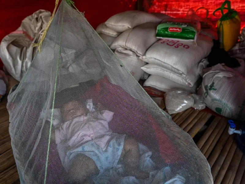 This photo taken on January 11, 2021 shows a Chin baby sleeping under a mosquito net in Bethel village in Hmawbi, on the outskirts of Yangon, where hundreds of members of the Chin ethnic community have settled after being displaced by fighting between Myanmar's military and the Arakan Army in the country's north.  Ye Aung THU / AFP