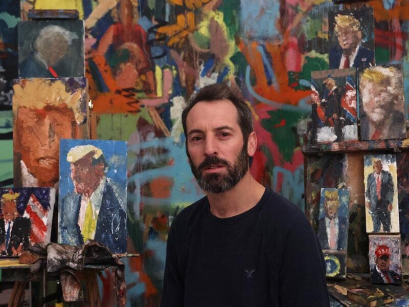 Israeli painter Iddo Markus poses for a picture at his studio, surrounded by his paintings of former US president Donald Trump, in the northern port city of Haifa, on January 22, 2021. Markus became fascinated by the "tragic figure" of Donald Trump, and the walls and floor of his studio are packed with some 120 portraits of the former US presidents. Emmanuel DUNAND / AFP
