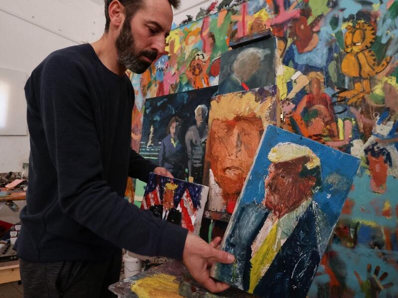 Israeli painter Iddo Markus arranges his paintings of former US president Donald Trump, at his studio in the northern port city of Haifa, on January 22, 2021. Markus became fascinated by the "tragic figure" of Donald Trump, and the walls and floor of his studio are packed with some 120 portraits of the former US presidents. Emmanuel DUNAND / AFP