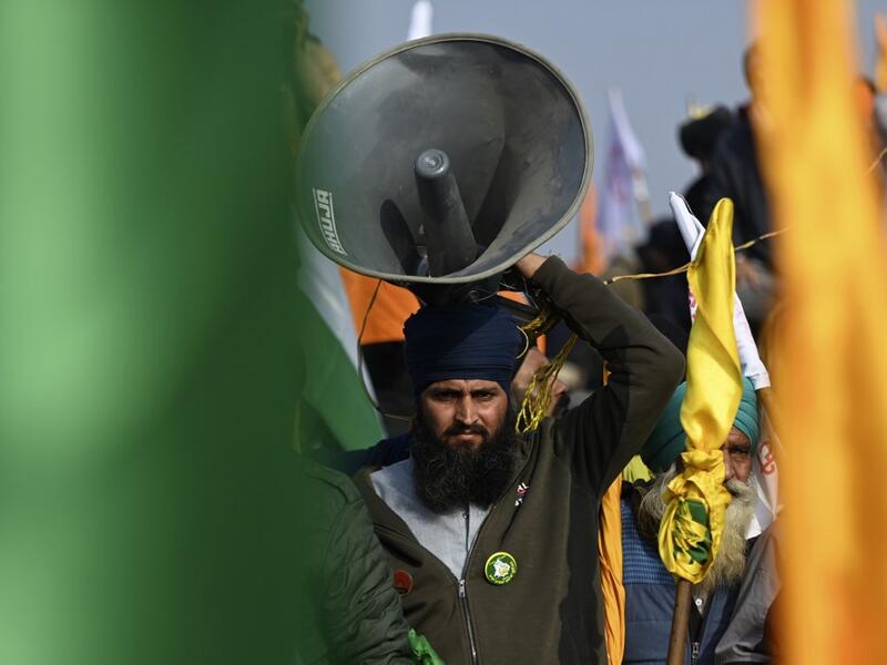 A farmer carries a loud speaker during a rally as farmers continue to demonstrate against the central government's recent agricultural reforms in New Delhi on January 26, 2021. Money SHARMA / AFP