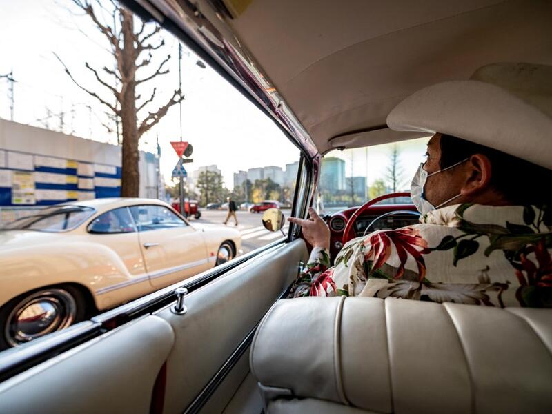 This picture taken on January 16, 2021 shows Hiroyuki Wada, who runs a vintage car service company, driving a 1959 Cadillac Coupe DeVille during a gathering of auto enthusiasts in Tokyo. A loose club of fans rolls up most weekends in central Tokyo to show off their Cadillacs, Chevrolets and other modern classic vehicles from the mid to late 20th century. Philip FONG / AFP
