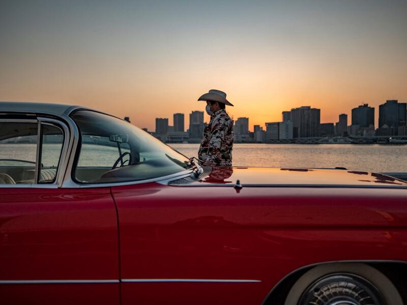 This picture taken on January 16, 2021 shows Hiroyuki Wada, who runs a vintage car service company, standing next to a 1959 Cadillac Coupe DeVille after a gathering of auto enthusiasts in Tokyo. A loose club of fans rolls up most weekends in central Tokyo to show off their Cadillacs, Chevrolets and other modern classic vehicles from the mid to late 20th century. Philip FONG / AFP
