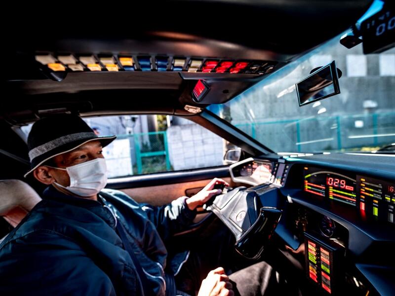 This picture taken on January 31, 2021 shows car enthusiast Masamune Isogai, who works for a logistics company in sales, driving a 1991 Trans Am Knight Rider in Urayasu, an eastern suburb of Tokyo. A loose club of fans rolls up most weekends in central Tokyo to show off their Cadillacs, Chevrolets and other modern classic vehicles from the mid to late 20th century. Philip FONG / AFP