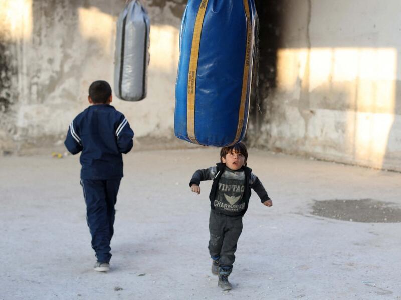 Syrian youths take part in a boxing workout held by local boxer Ahmad Dwara (unseen) inside a damaged building in the town of Atareb in the rebel-held western countryside of Syria's Aleppo province, on February 11, 2021. AAREF WATAD / AFP