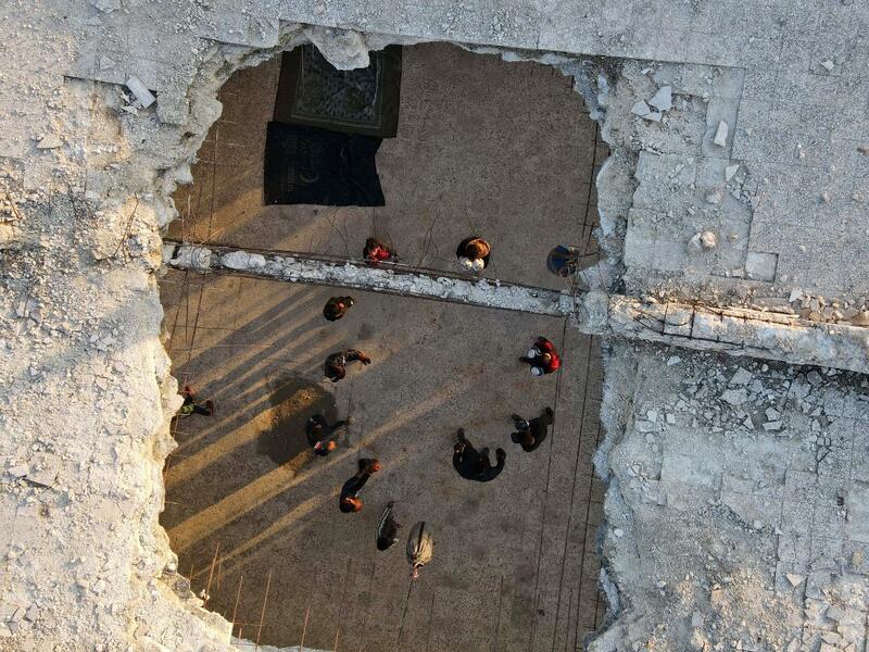 Syrian youths take part in a boxing workout held by local boxer Ahmad Dwara (unseen) inside a damaged building in the town of Atareb in the rebel-held western countryside of Syria's Aleppo province, on February 11, 2021. AAREF WATAD / AFP