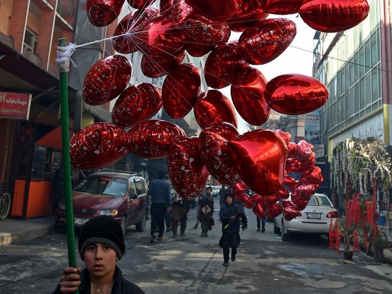 A child carries balloons to sell on Valentine's Day in Kabul on February 14, 2021. WAKIL KOHSAR / AFP