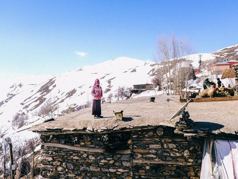 In this photograph taken on February 15, 2021, Kurdish girl looks at members of the Bahcesaray public hospital vaccination team as they arrive at the village of Guneyyamac in eastern Turkey, as part of an expedition to vaccinate residents of 65 years old or above with Sinovac's CoronaVac Covid-19 vaccine. Turkey's population of more than 83 million is spread out across Europe and Asia and covers some seemingly impregnable terrain. The vaccination effort with China's CoronaVac jab kicked off with a bang in m