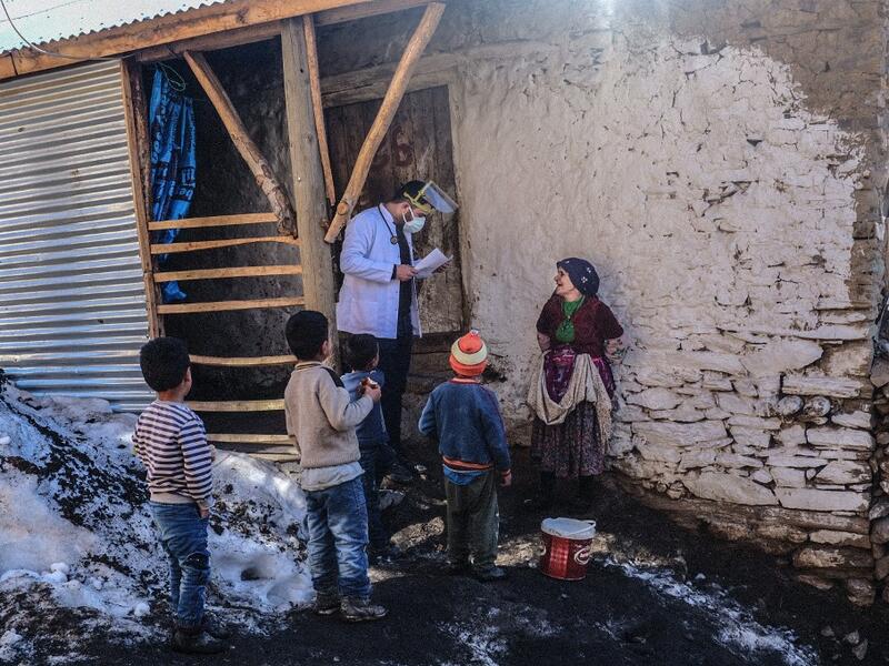 In this photograph taken on February 15, 2021, doctor Akay Kaya (L) from Bahcesaray public hospital vaccination team speaks with a Kurdish woman at the village of Guneyyamac in eastern Turkey, as part of an expedition to vaccinate residents of 65 years old or above with Sinovac's CoronaVac Covid-19 vaccine. Turkey's population of more than 83 million is spread out across Europe and Asia and covers some seemingly impregnable terrain. The vaccination effort with China's CoronaVac jab kicked off with a bang in