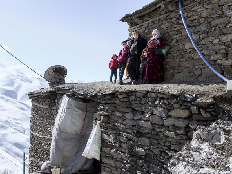 n this photograph taken on February 15, 2021, Kurdish villagers look at members of the Bahcesaray public hospital vaccination team as they arrive at the village of Guneyyamac in eastern Turkey, as part of an expedition to vaccinate residents of 65 years old or above with Sinovac's CoronaVac Covid-19 vaccine. Turkey's population of more than 83 million is spread out across Europe and Asia and covers some seemingly impregnable terrain. The vaccination effort with China's CoronaVac jab kicked off with a bang i