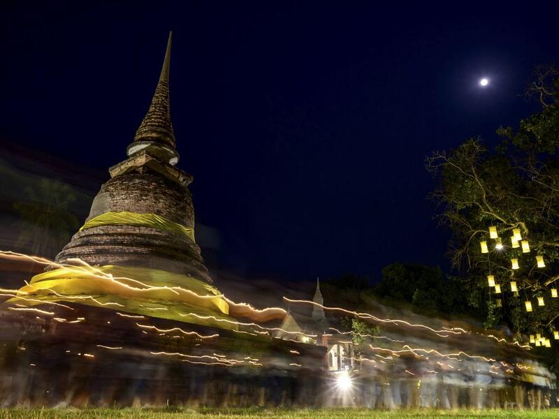 A long exposure photograph shows Buddhist monks leading a candlelight procession around Wat Traphang Thong to celebrate Makha Bucha Day in Sukhotai on February 26, 2021. Mladen ANTONOV / AFP