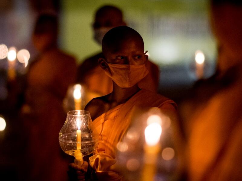 Buddhist monks hold candles during Makha Bucha celebrations at Wat Dhammakaya, north of Bangkok on February 26, 2021. Jack TAYLOR / AFP