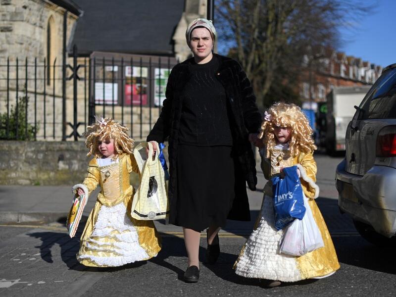 Young children dressed in costume in celebration of the Jewish holiday of Purim, are escorted along a street in the Orthodox Jewish neighborhood of Stamford Hill in north London on February 26, 2021. The carnival-like Purim holiday is celebrated with parades and costume parties to commemorate the deliverance of the Jewish people from a plot to exterminate them in the ancient Persian Empire 2,500 years ago, as recorded in the Biblical Book of Esther. DANIEL LEAL-OLIVAS / AFP