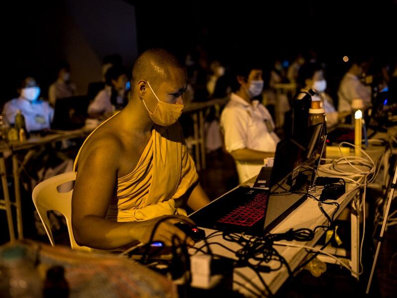 A Buddhist monk manages a video conferencing for people unable to attend Makha Bucha celebrations due to the Covid-19 coronavirus pandemic at Wat Dhammakaya, north of Bangkok on February 26, 2021. Jack TAYLOR / AFP