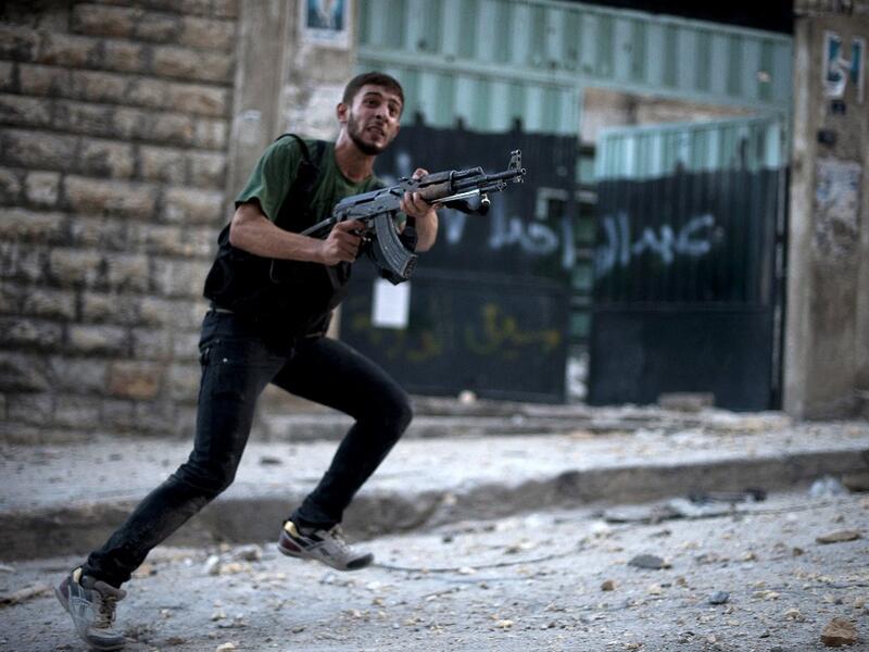 Syrian rebel aims his weapon during clashes with government forces 
