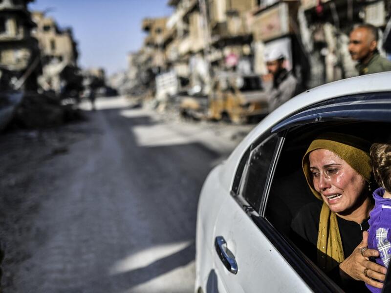  woman cries as she looks at her house in Raqa