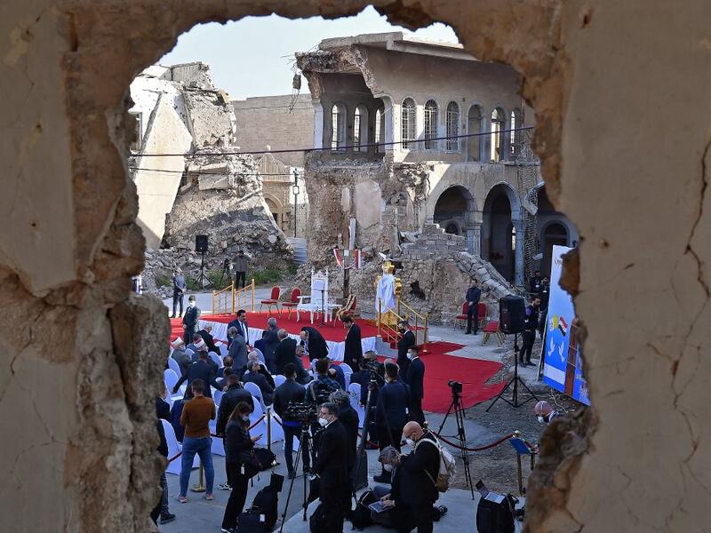 Iraqis gather near the ruins of the Syriac Catholic Church 