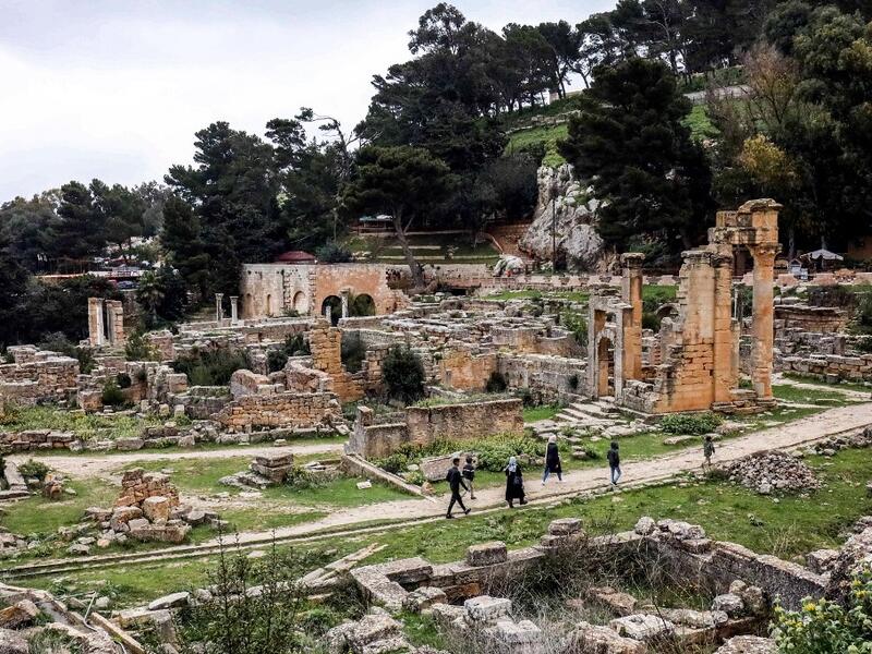 People walk through the remains of the Sanctuary of Apollo in the ruins of Libya's eastern ancient city of Cyrene 