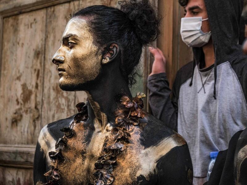 A carnival participant dressed in costume and wearing body paint 