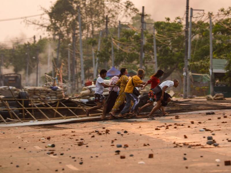 People run past makeshift barricades 