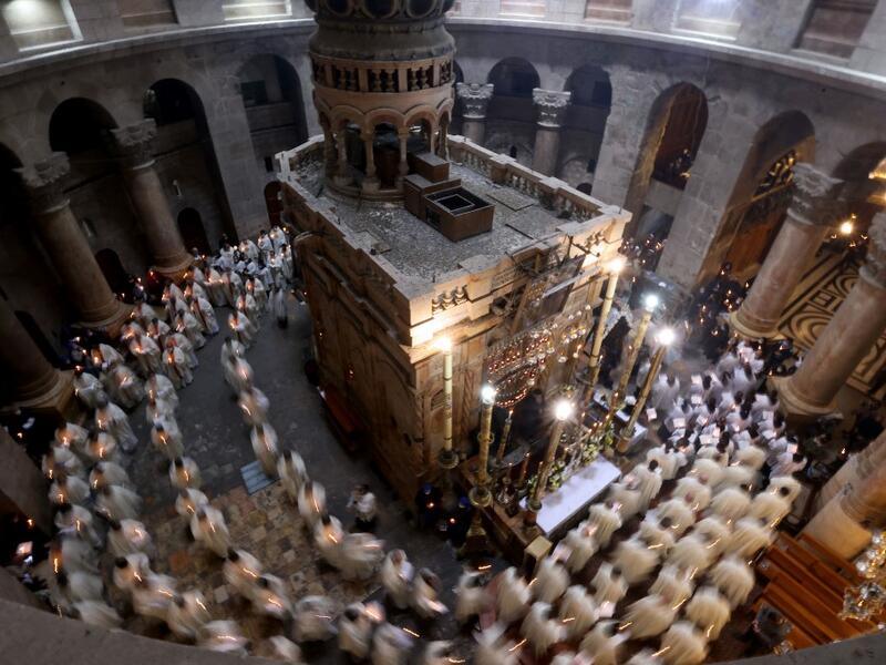 Christian worshippers, monks, and friars walk in procession around the Edicule, traditionally believed to be the burial site of Jesus Christ