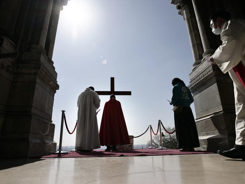 Archbishop of Paris Michel Aupetit carries the holy cross at the Way of the Cross ceremony during the Good Friday as part of the Holy Week 