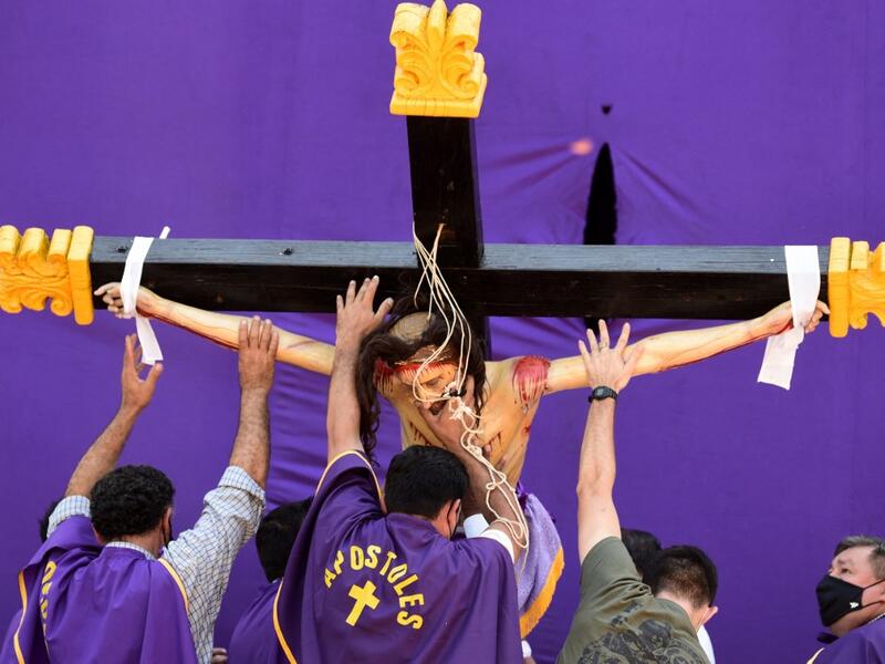 Catholic faithful reenact the Way of the Cross during Good Friday in Capiata